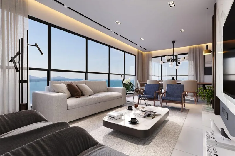 Living do apartamento tipo com janelas amplas voltadas para o mar